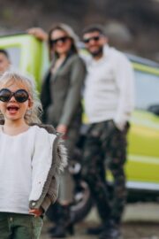 Young modern family travelling by car and stopped for a walk in park